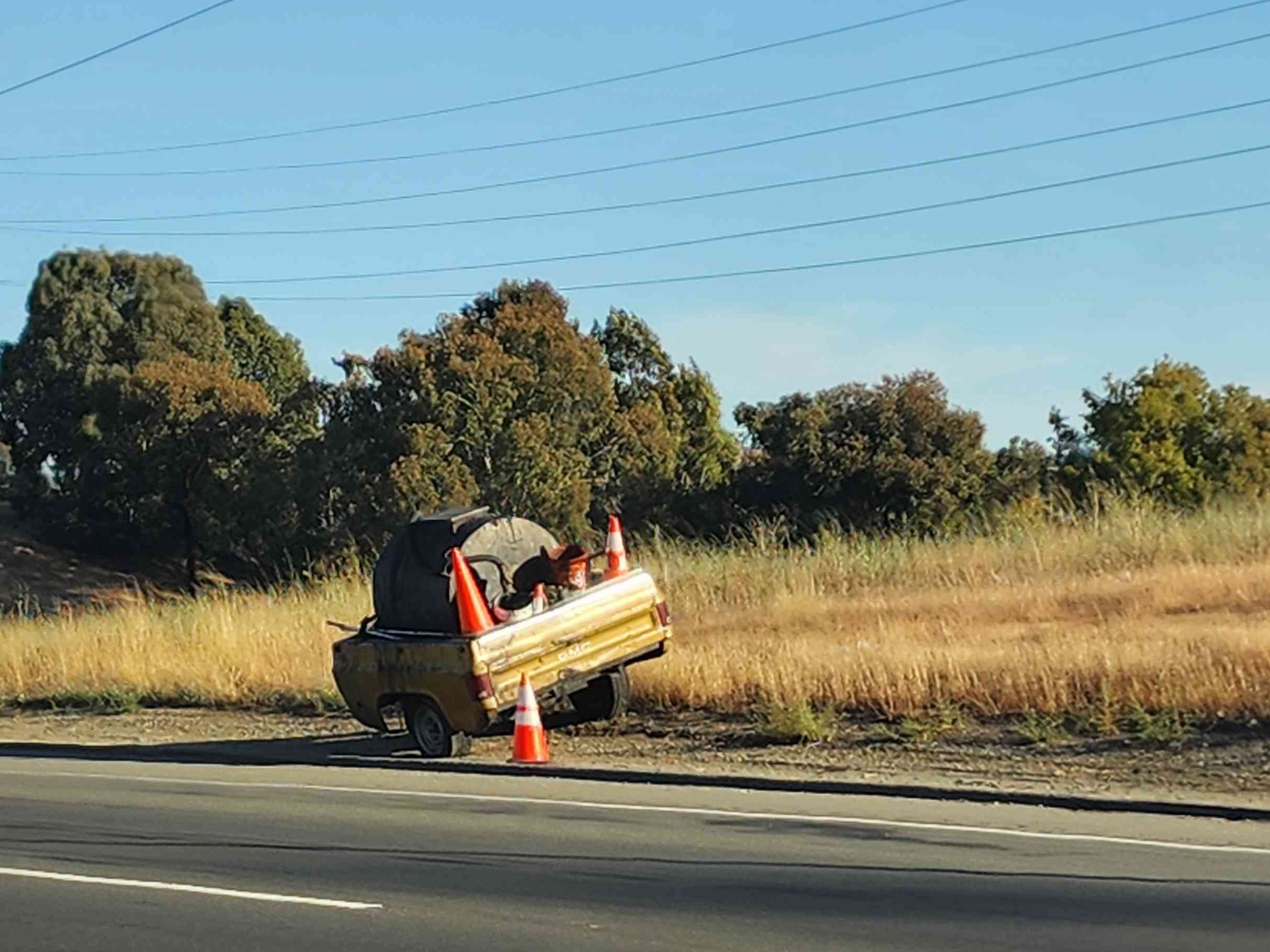 The back of a pickup truck modified as a trailer with a tar boiler